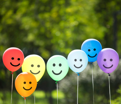 line of coloured balloons with smiling faces on them